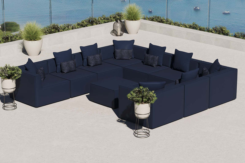 Luxury outdoor teak sectional sofa and matching club chairs with plush grey cushions on a stone patio.