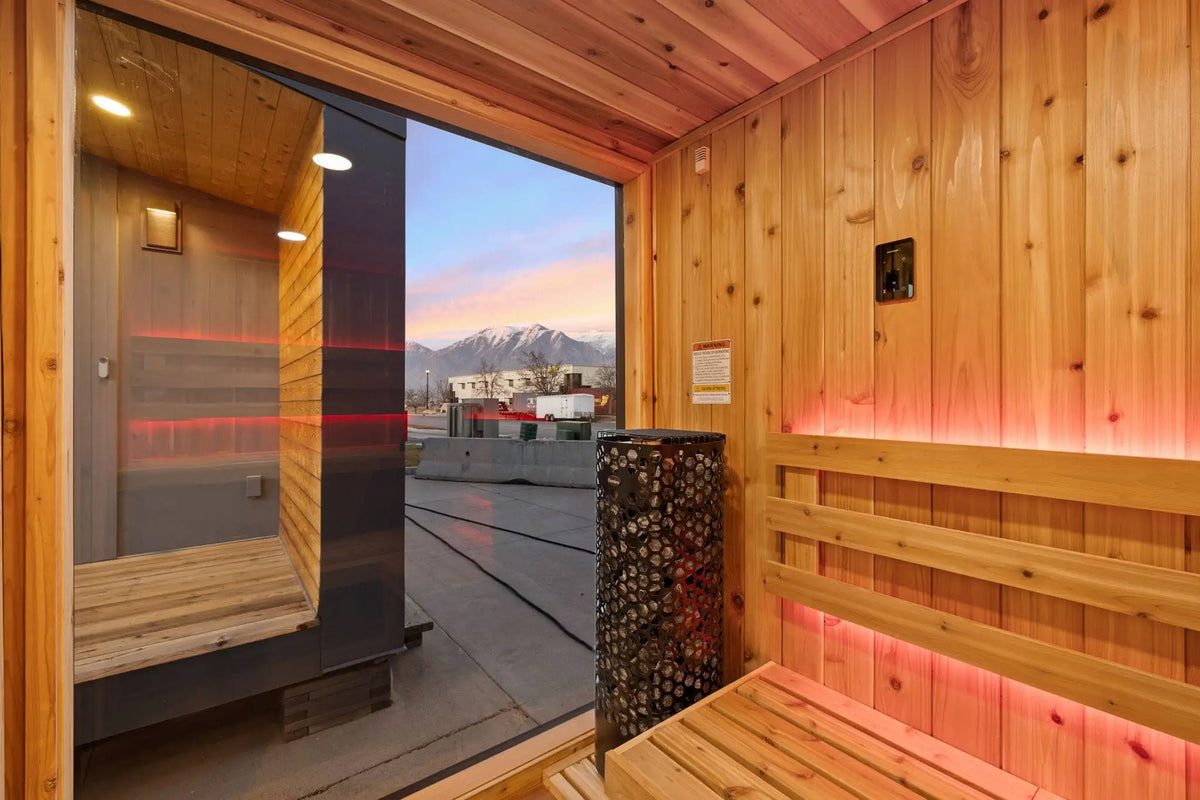 Wooden sauna with a view of mountains through the glass door.