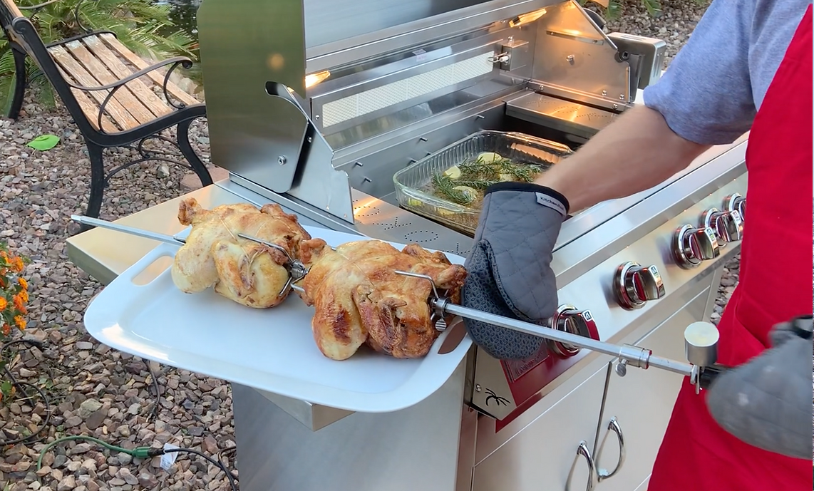 Person grilling chicken on a barbecue grill outdoors