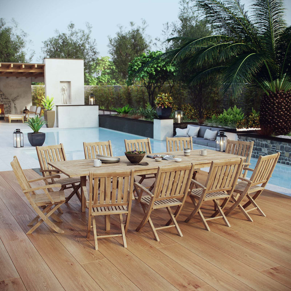 Wooden outdoor dining set with chairs on a wooden deck by a pool.