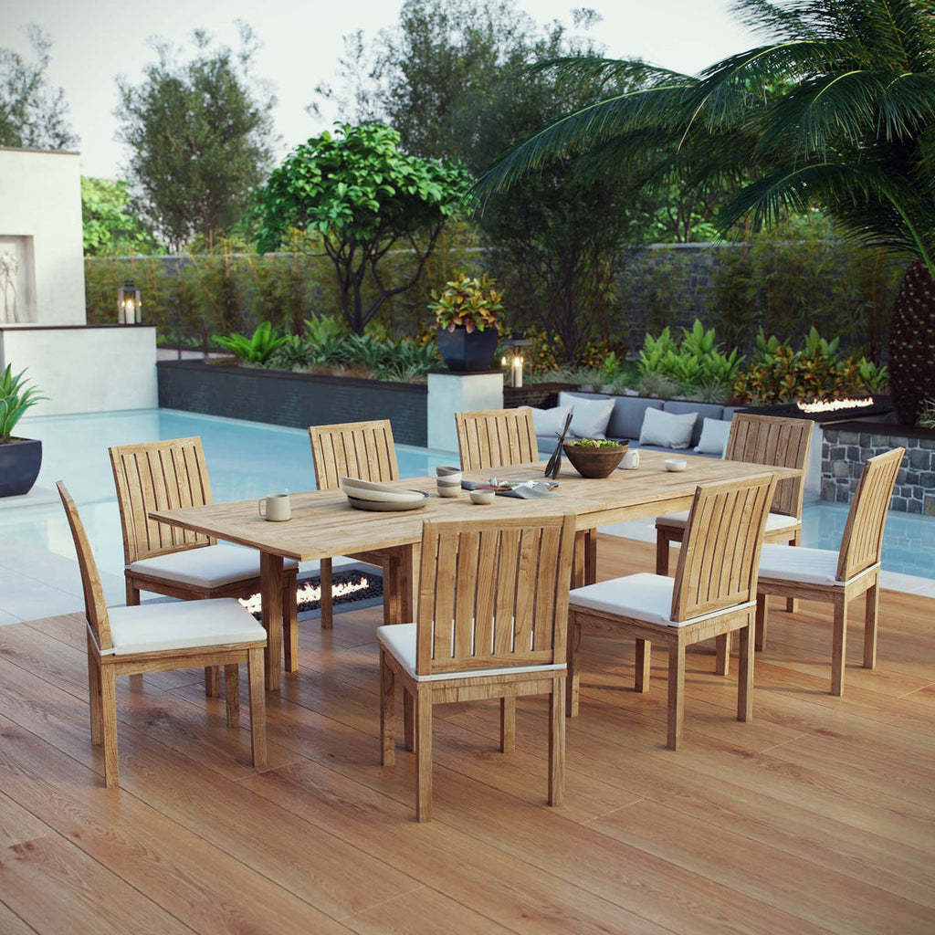 Outdoor dining set with wooden table and chairs on a wooden deck by a pool.