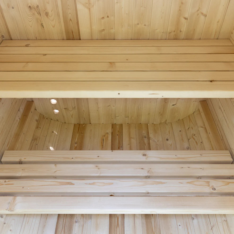 Wooden interior of a sauna with benches and ceiling.