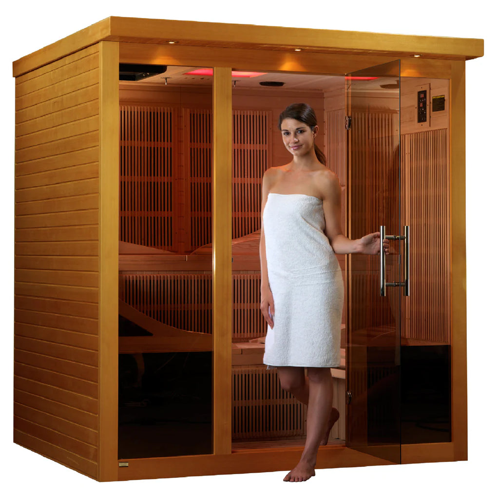 Woman in a white towel standing in an infrared sauna with wooden interior.