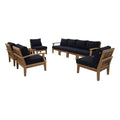 Outdoor furniture set with wooden chairs and sofa with navy cushions on a white background