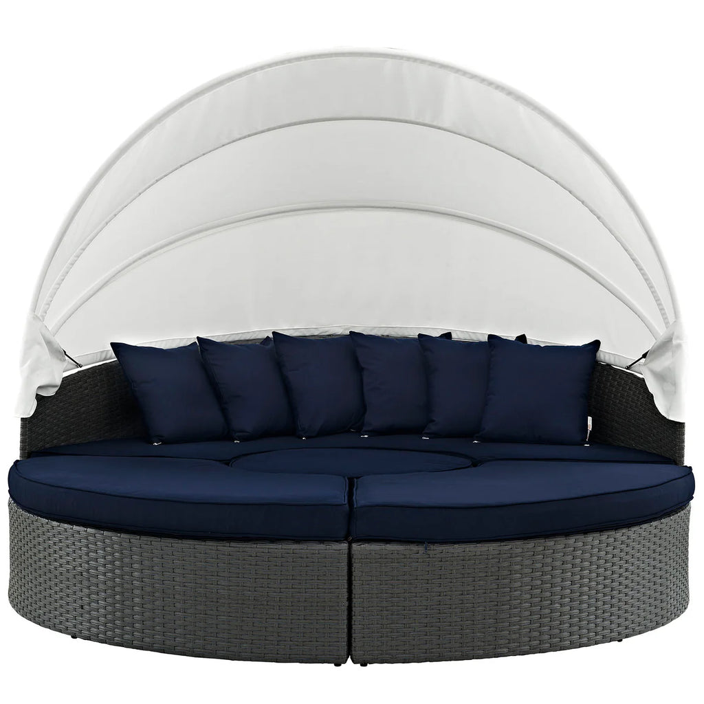 Round outdoor daybed with canopy and navy cushions on a white background