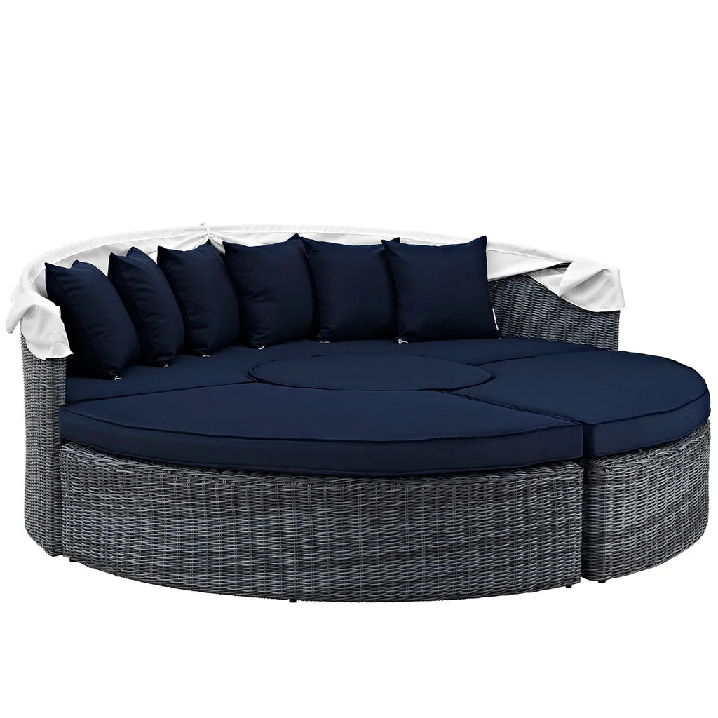 Round outdoor sofa with navy cushions and a white cover on a white background