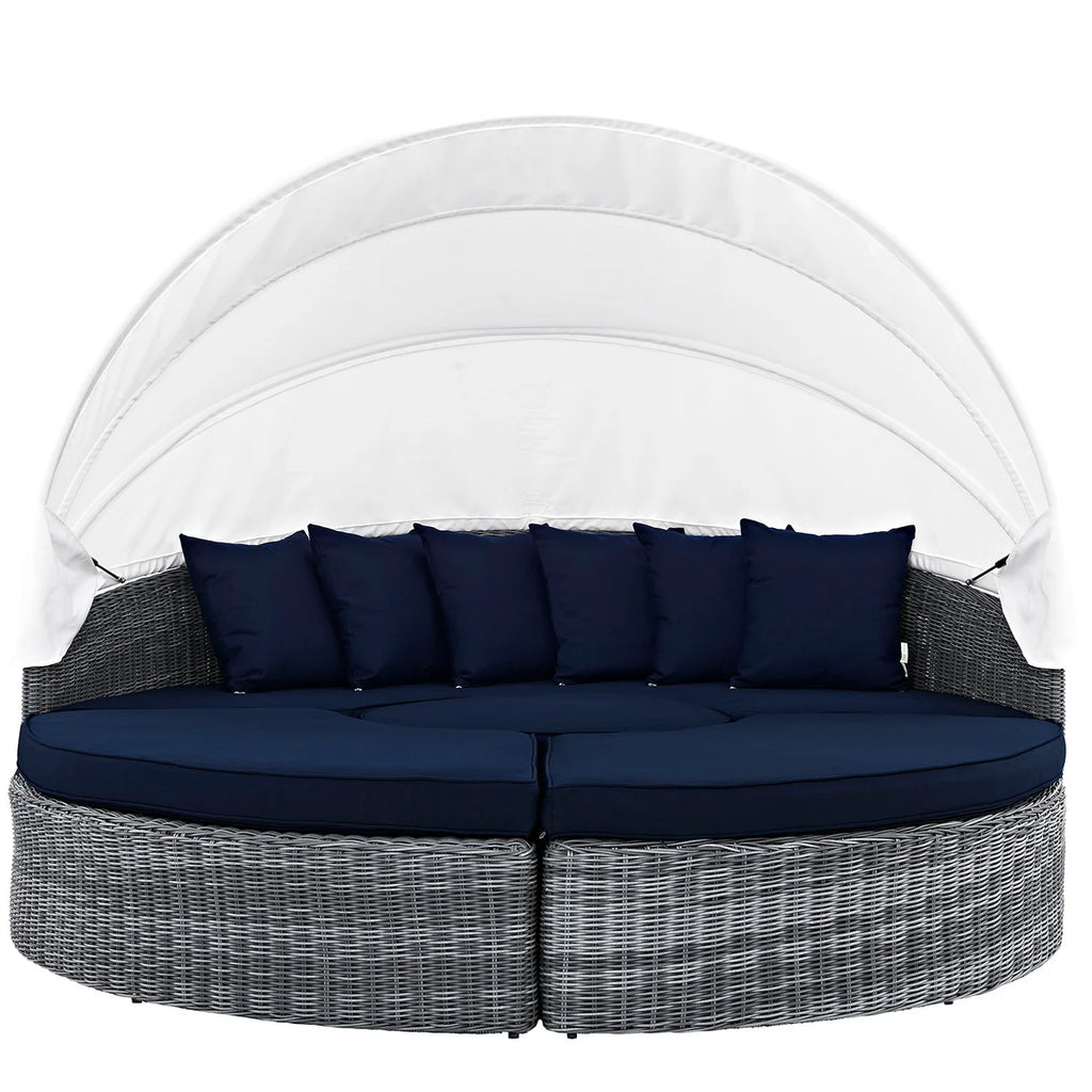 Round outdoor daybed with canopy and navy cushions on a white background