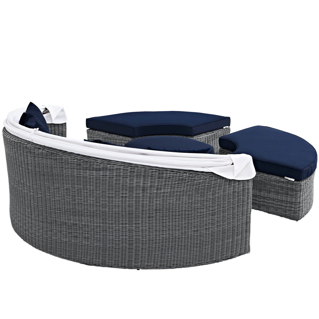 Outdoor furniture set with gray wicker chairs and navy cushions on a white background