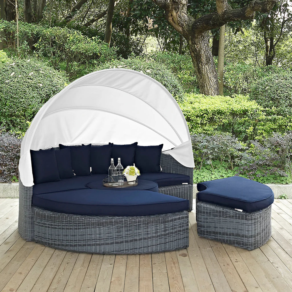 Outdoor patio daybed with canopy and cushions on a wooden deck