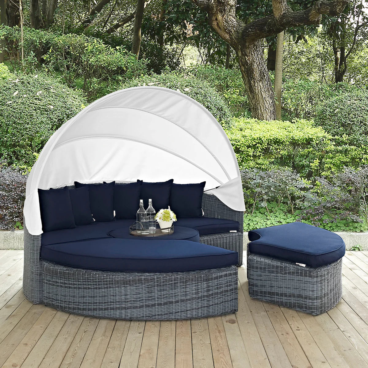 Outdoor patio daybed with canopy and cushions on a wooden deck