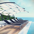 Row of chaise lounge chairs under a canopy by a pool with a scenic background