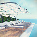 White lounge chaise chairs under a canopy by a pool with a scenic background