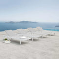 White lounge chairs on a terrace with a scenic ocean view