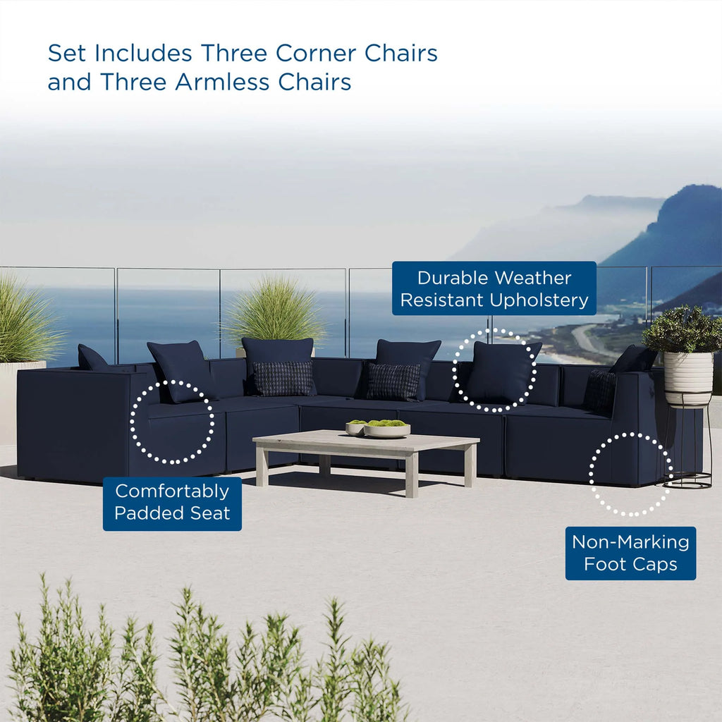 Outdoor furniture set with blue sectional sofa and chairs on a patio with ocean view.