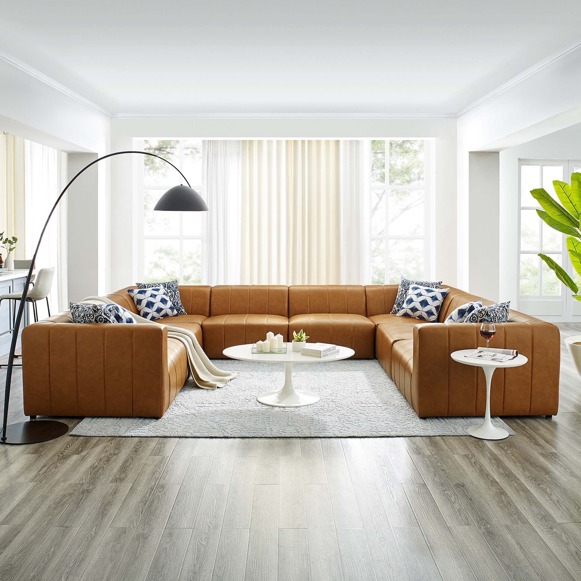 brown sectional sofa with throw pillows, side tables lamp, and bright white ceiling 