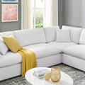Modern living room with a white sectional sofa, yellow throw blanket, and decorative items.