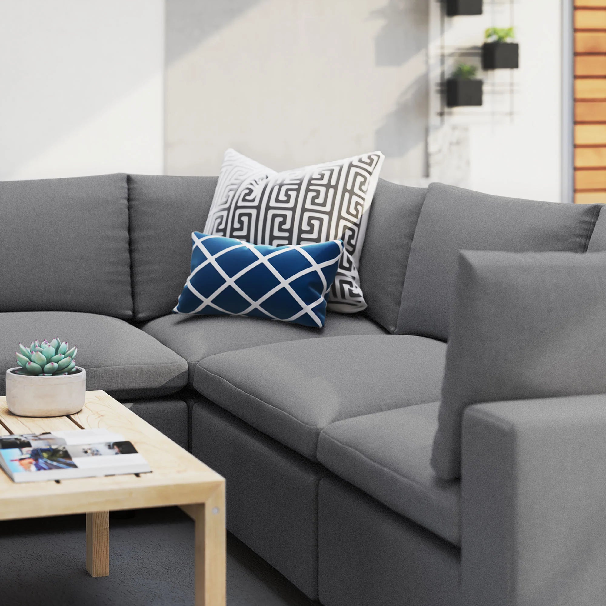 Gray sectional sofa with decorative pillows and a small table.