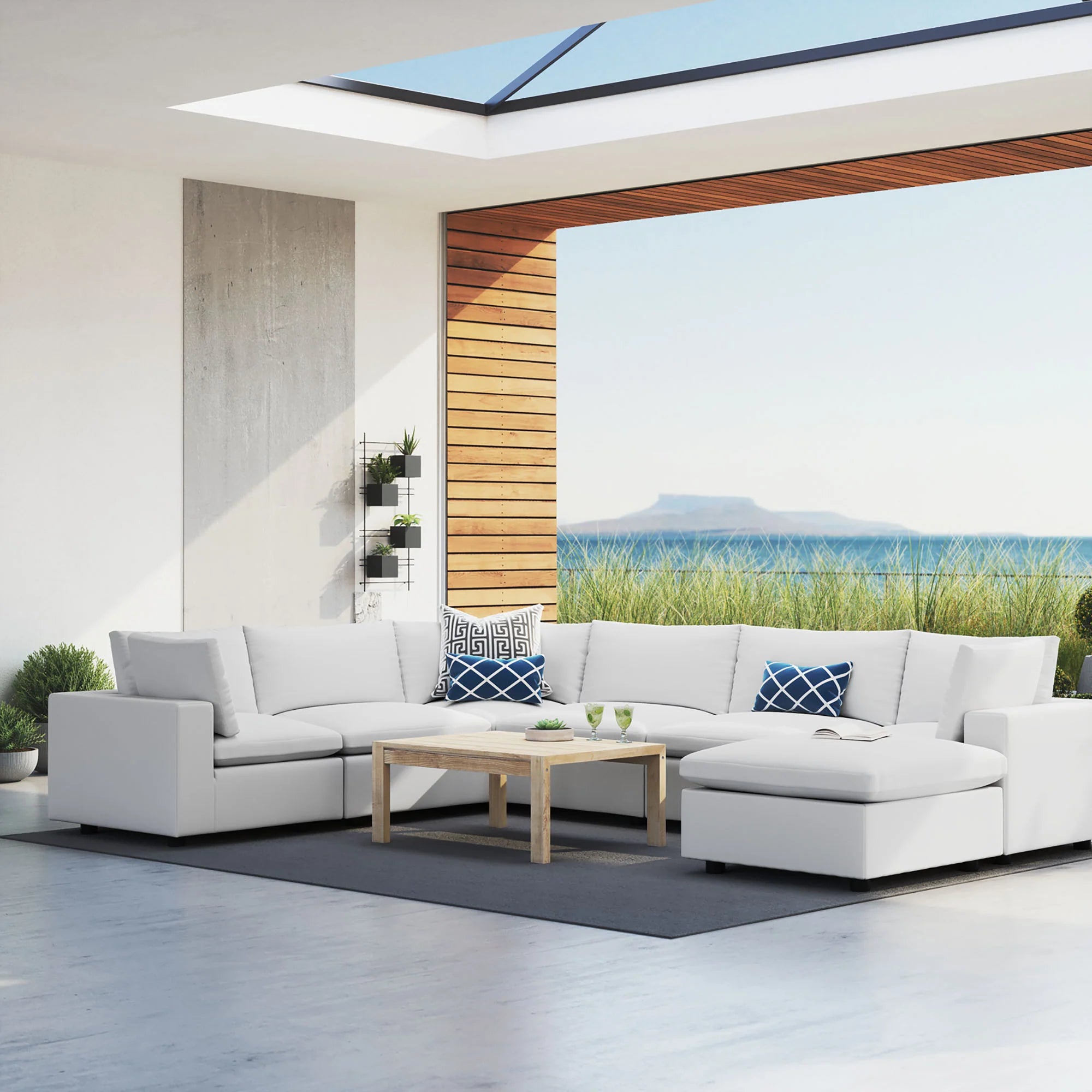 Modern outdoor patio with a sectional sofa, coffee table, and scenic view of water.
