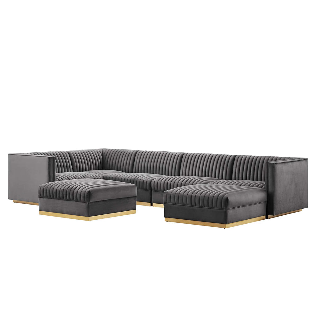 Gray sectional sofa with gold legs on a white background