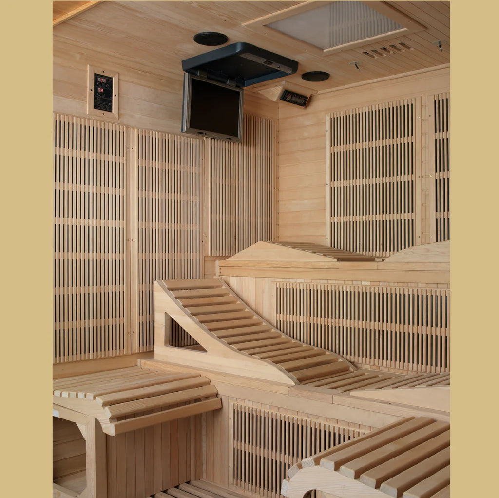 Wooden sauna interior with benches and a television mounted on the wall.