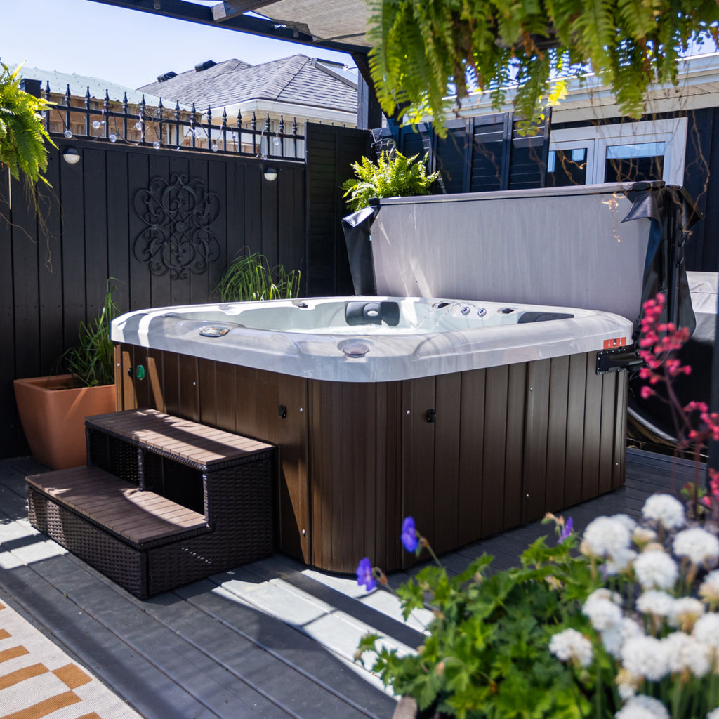 Hot tub on a patio with plants and flowers around