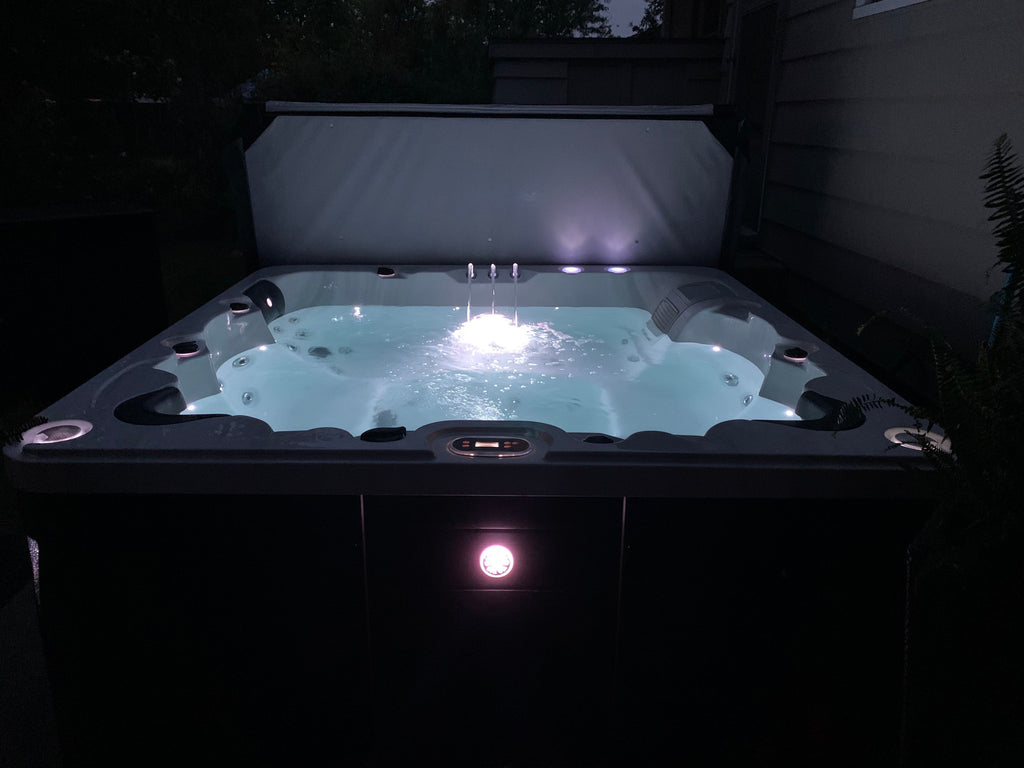 Hot tub with glowing lights in a dark outdoor setting