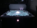 Hot tub with glowing lights in a dark outdoor setting