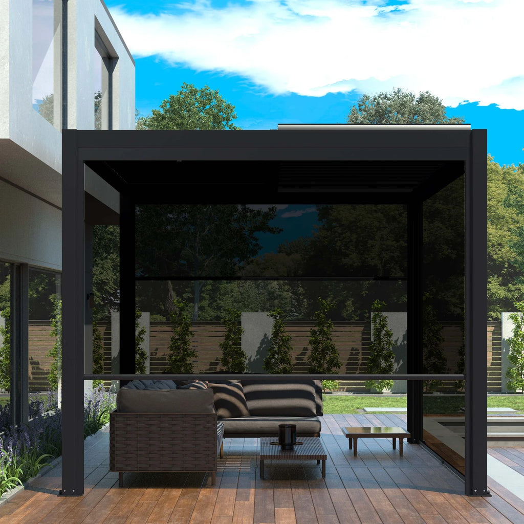 Modern black metal patio pergola with dark mesh side screens, housing a wicker sofa, striped cushions, and a coffee table on a wooden deck, set against a garden background under a blue sky.