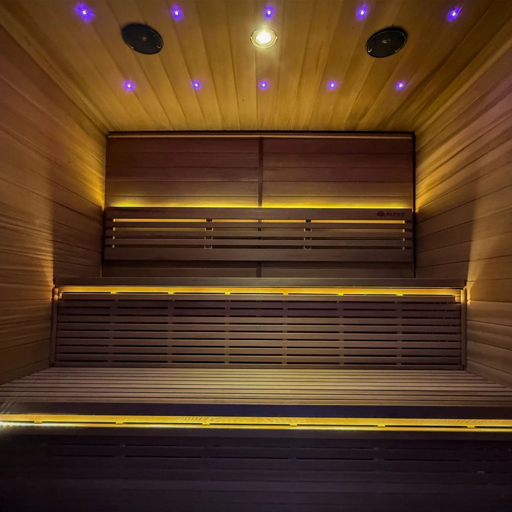 Wooden sauna interior with benches and LED lights on the ceiling.