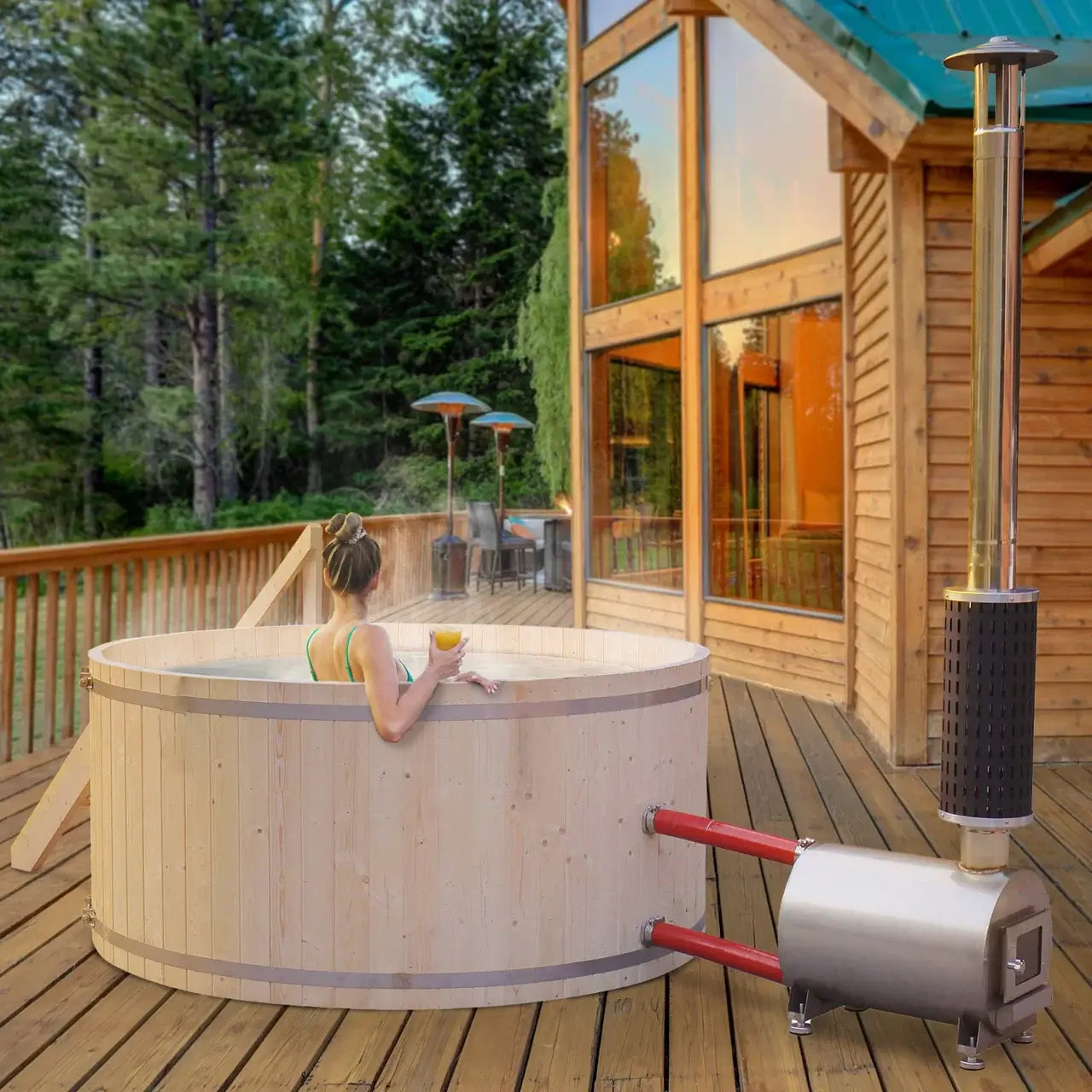 Wooden hot tub on a wooden deck with a view of a cabin and forest.