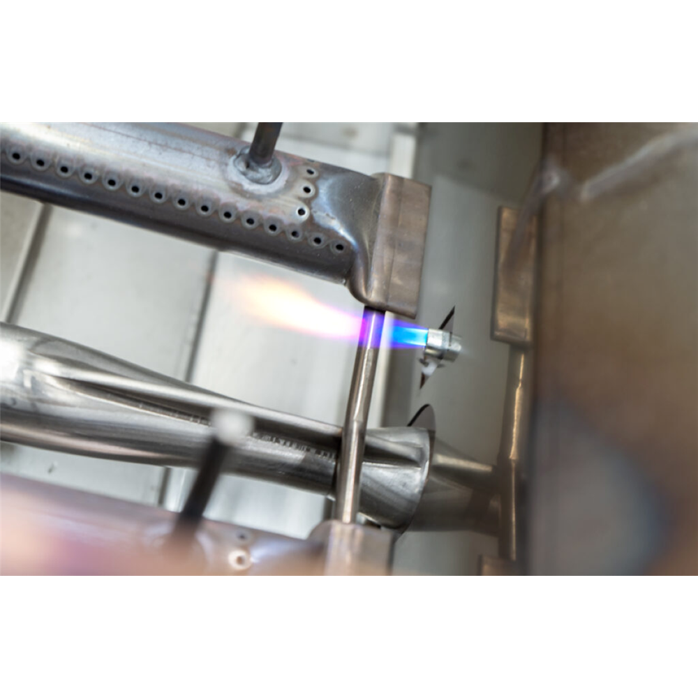 Metallic component with a flame applied during a manufacturing process