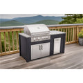 A large outdoor kitchen island set with a stainless steel gas grill, granite-look countertop, double cabinet doors, and a side storage compartment, shown on a wooden deck with a mountain landscape in the background.