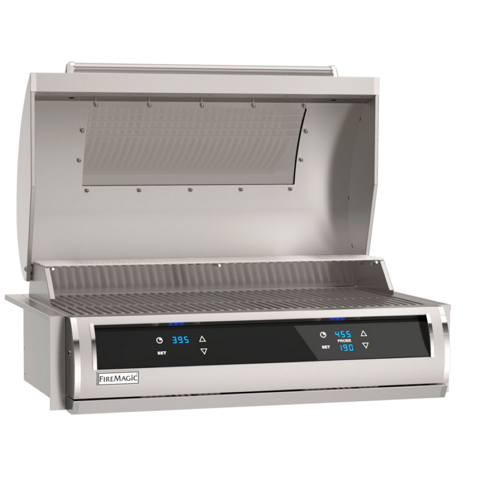 A stainless steel FireMagic outdoor gas grill with its lid open, showing the interior burner grates and a black control panel with blue digital displays on a white background.