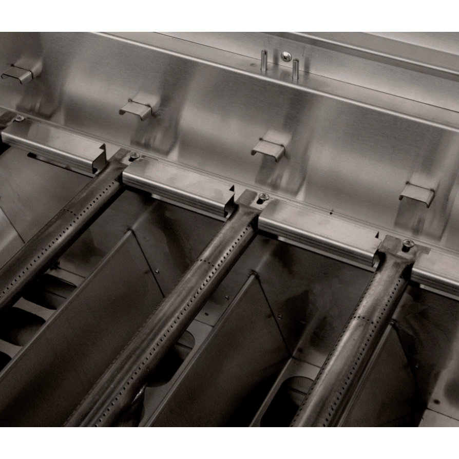 Close-up of a stainless steel industrial heating or cooking apparatus with metal plates, supports, and perforated bars.