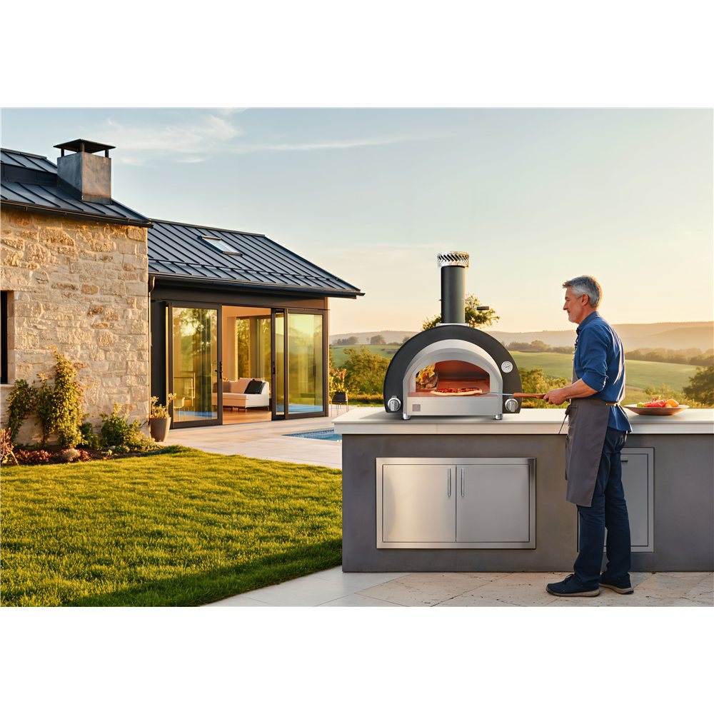 Man standing next to a pizza oven on a patio with a scenic view