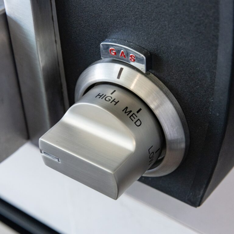 Stainless steel gas stove knob with 'High', 'Med', and 'Low' labels on a black background.