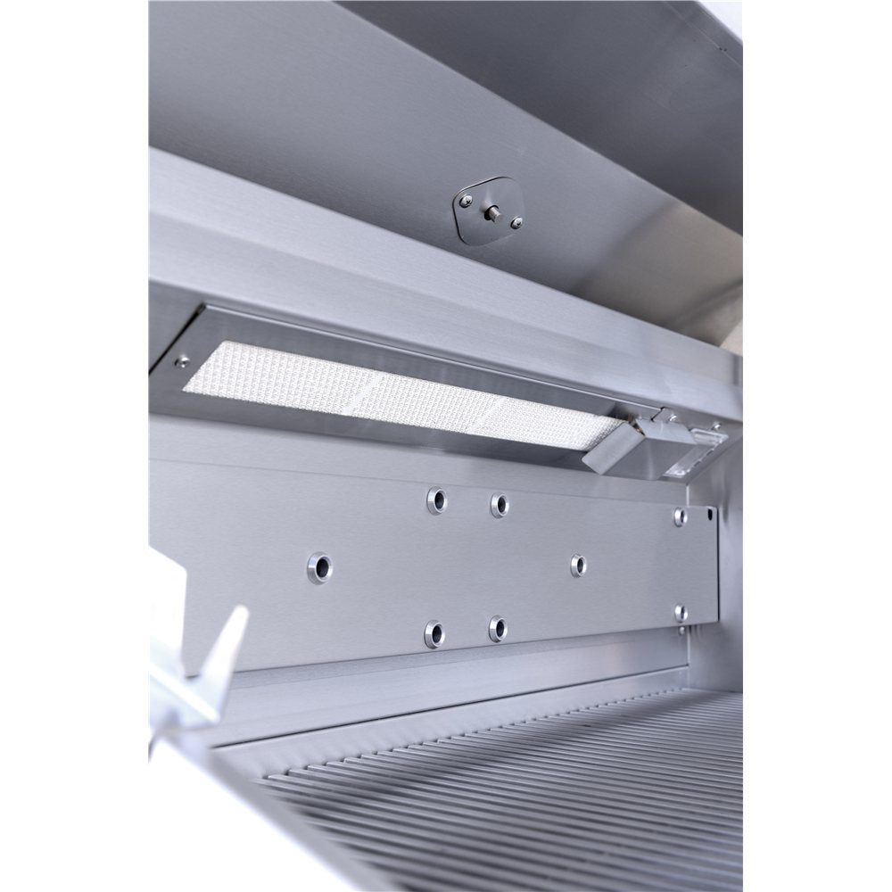 Stainless steel range hood with light on a white background