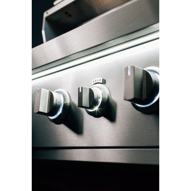 Stainless steel stove with control knobs on a white background