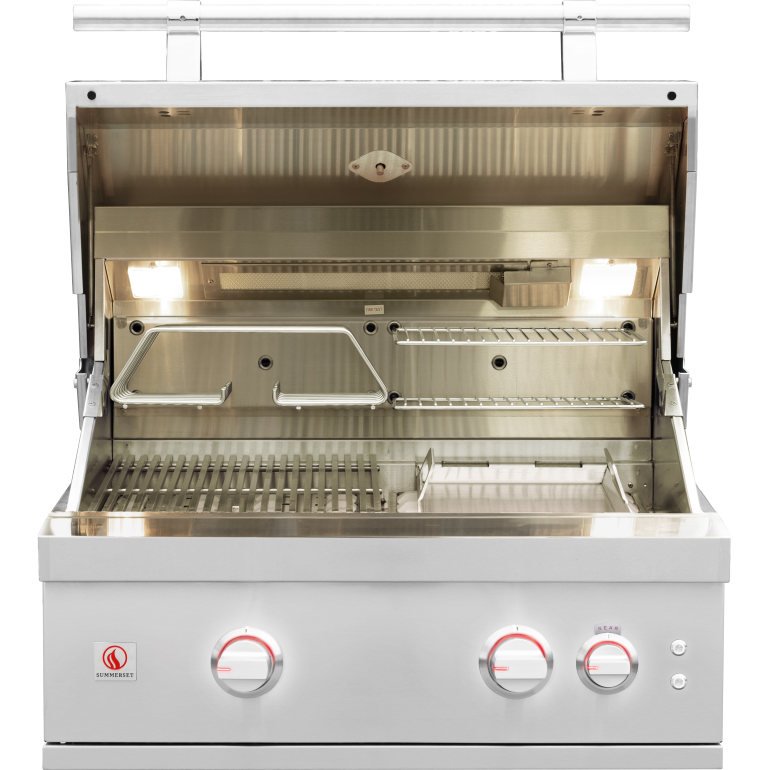A stainless steel outdoor gas grill with its lid open, showing the interior grates, shelves, and built-in lights. The front control panel has three round knobs with red markings and a small red logo on the left.