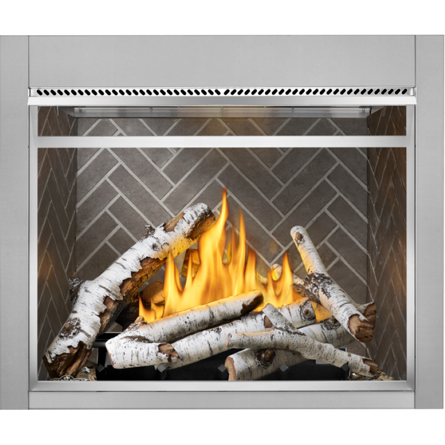 A gas fireplace insert with a stainless steel frame, featuring a realistic arrangement of white-barked logs and bright yellow-orange flames against a gray herringbone tile background.