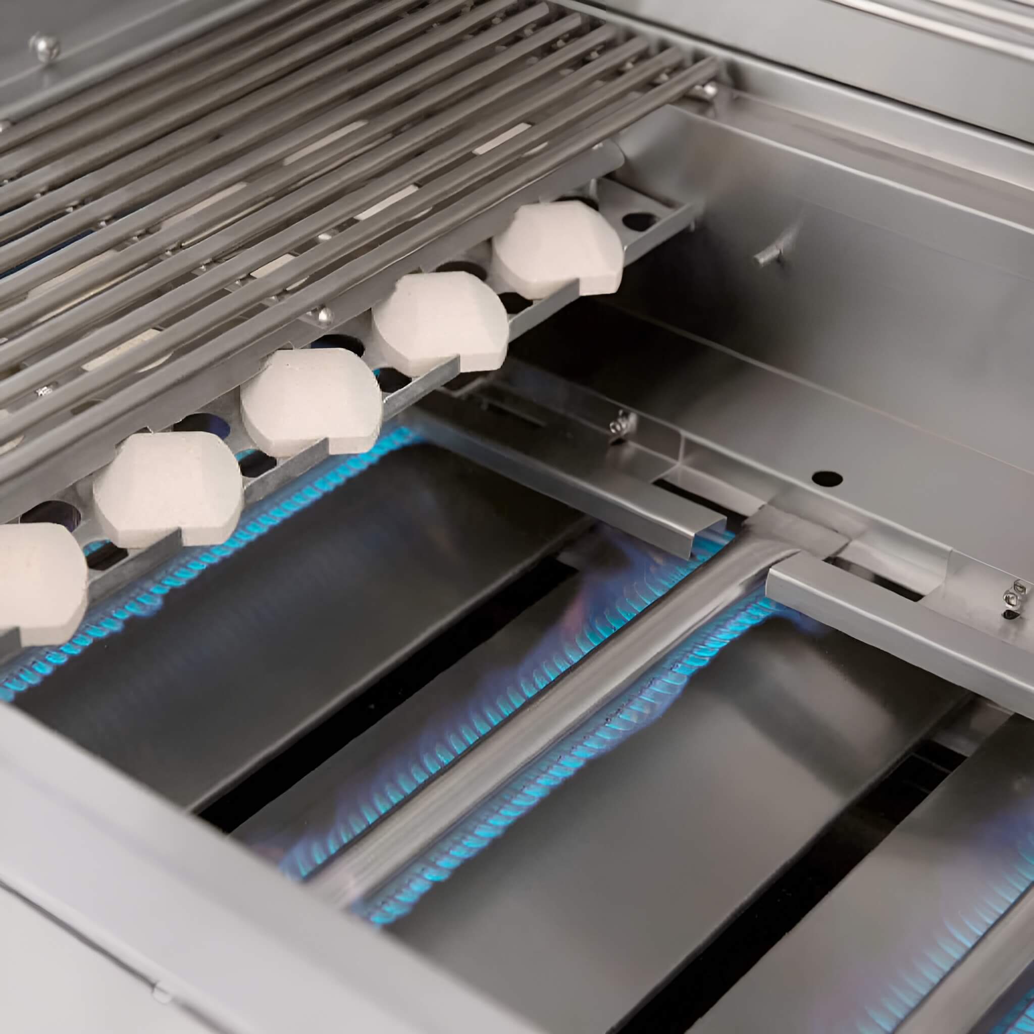 Close-up of a gas grill with lit burners and a metal grate.
