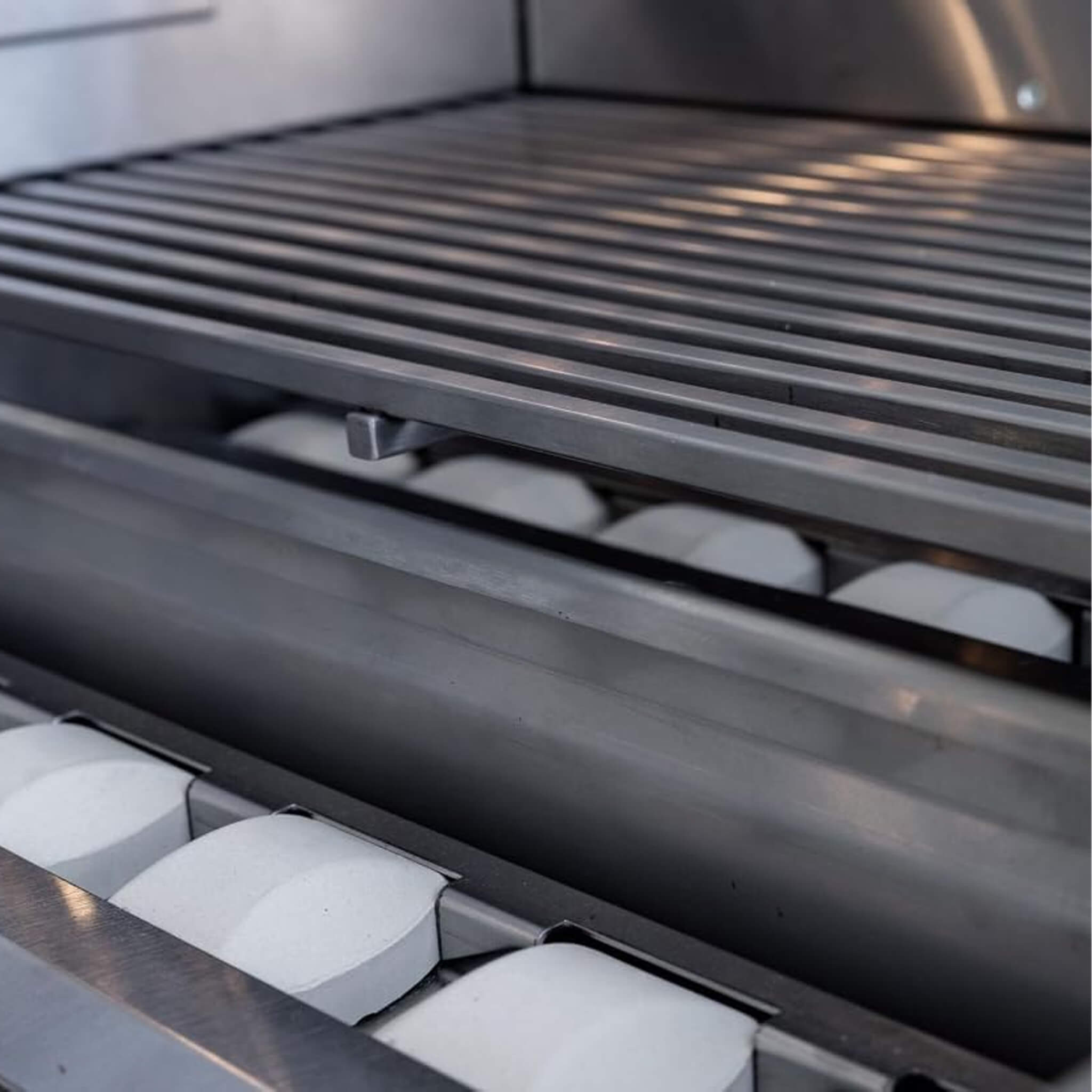 Bread rolls in a bakery oven with metal racks.