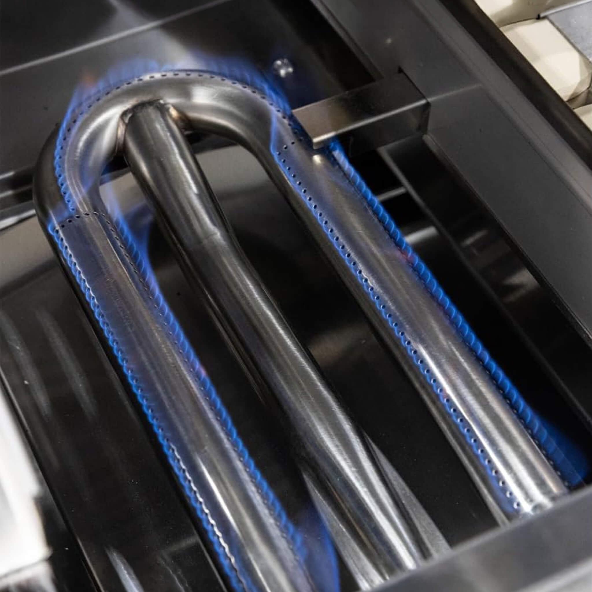 Close-up of a grill burner with blue gasket on a stove