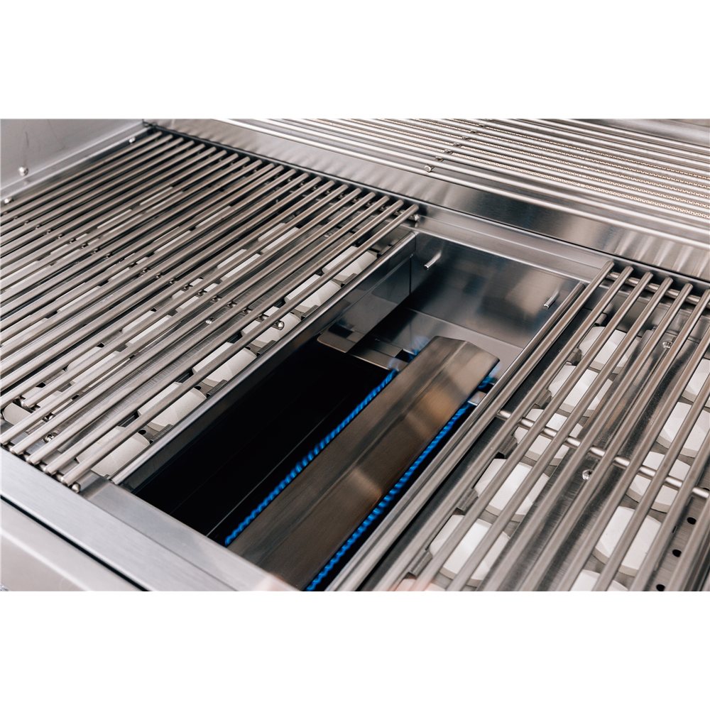 Close-up of a stainless steel gas grill burner with metal grate bars and a blue gas jet visible inside the combustion chamber.