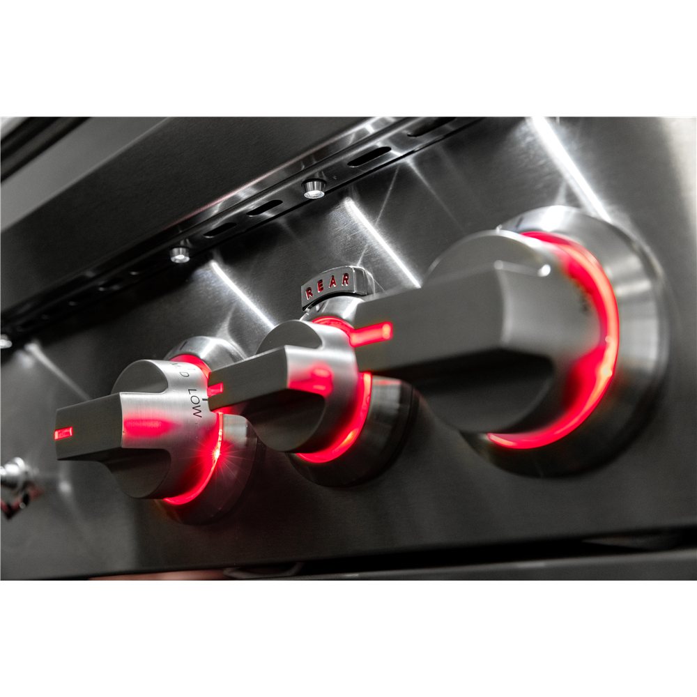 Close-up of gas stove knobs with red indicator lights on a metallic surface.